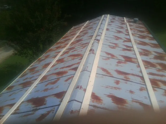 Rusted metal roof panels with new wood purlins before replacement — Storm Damage Roof Repair in Dyersburg by Roofing Brothers